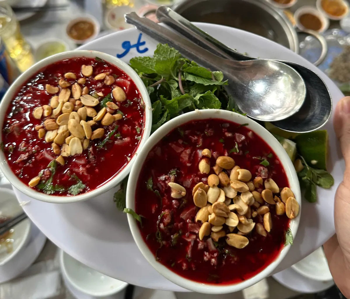 Hai bát tiết canh dê đỏ tươi rắc đầy đậu phộng